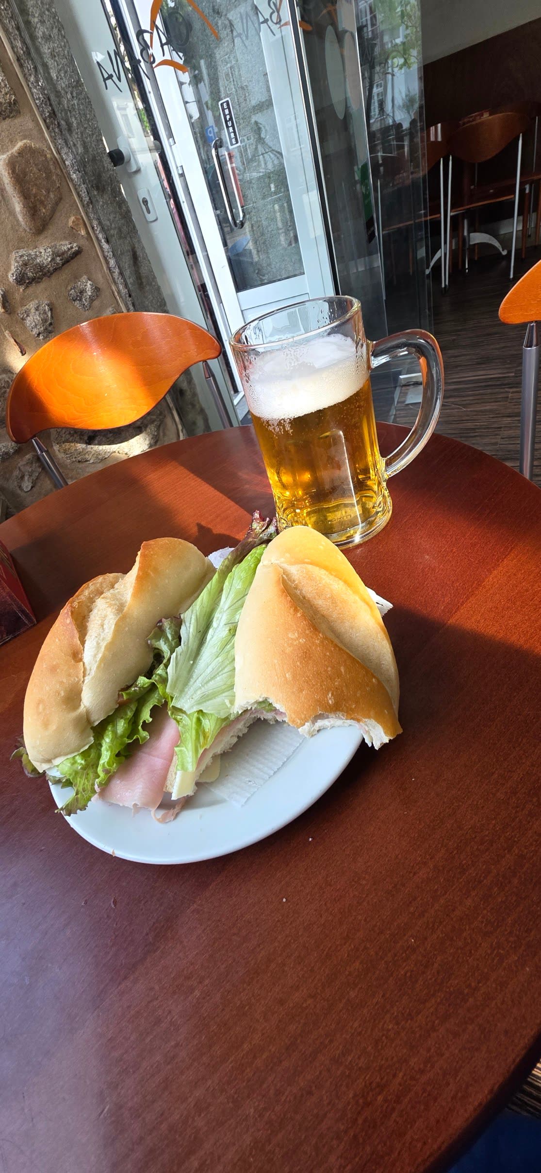 Bocadillo sandwich and a mug of beer on a café table