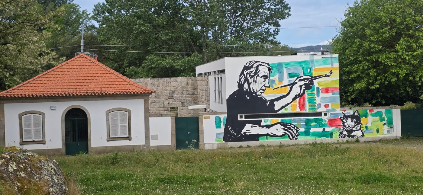 Mural of a painter and a cat on a building wall
